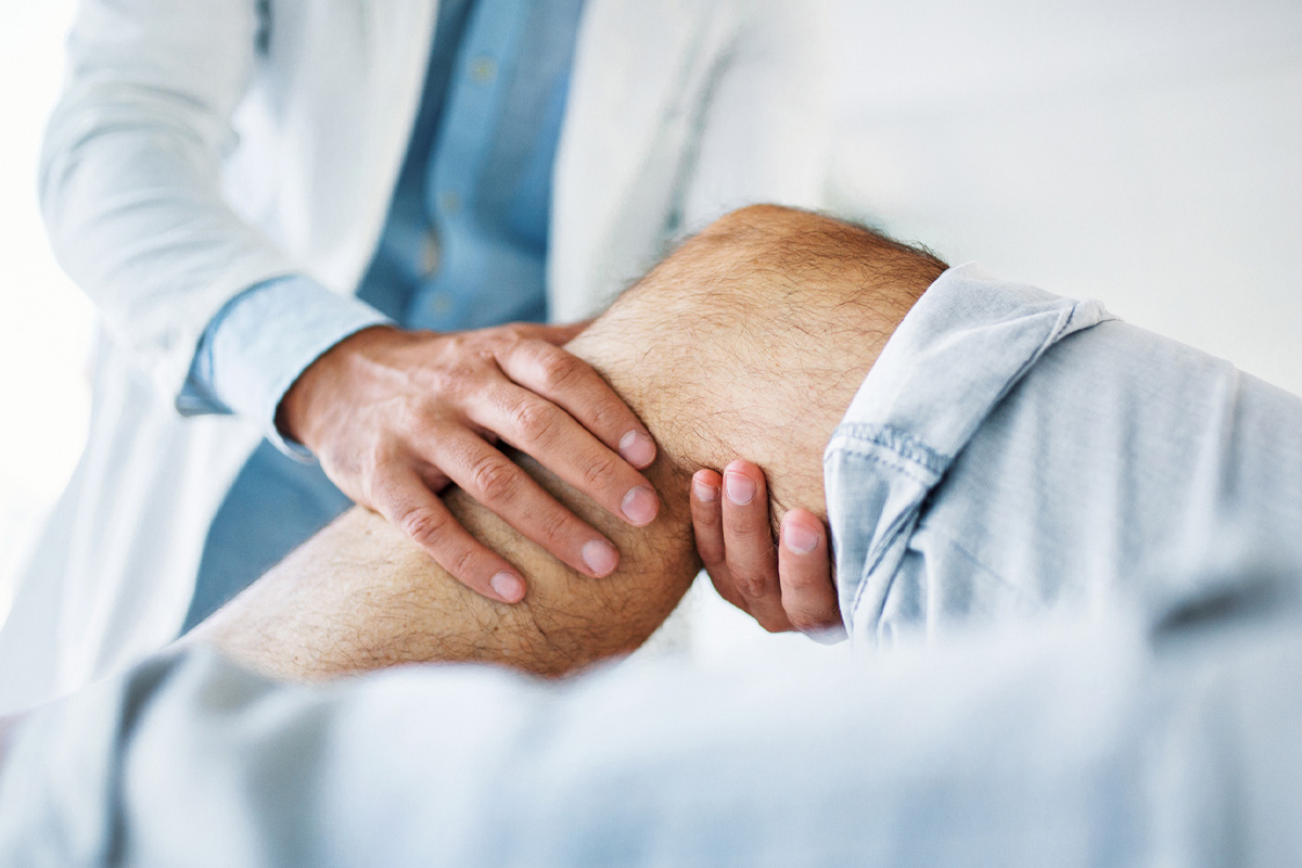Doctor examining a patient’s knee during a consultation for pain management in Parsippany-Troy Hills.